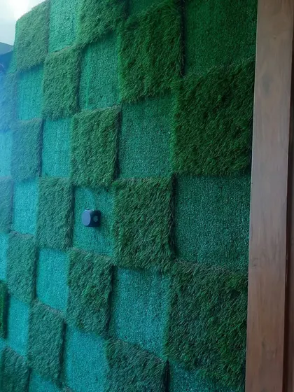 A unique checkerboard pattern created using two different piles of artificial grass. This design adds a playful and modern touch to an otherwise simple balcony wall.