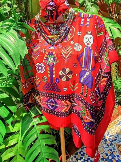 This vibrant red kaftan top features a unique folk-art print and comes with a matching bandana. It’s a fun, free-size piece that brings a splash of colour and personality to your wardrobe.