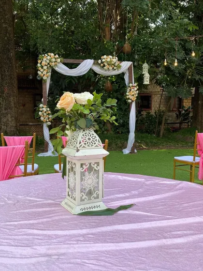 Detail is key in our event styling. This centerpiece, with its intricate lantern and fresh roses, perfectly complements the garden theme of this beautiful wedding reception.