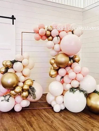 This is a modern, deconstructed balloon arch using a copper frame. The clusters of white, blush, and gold balloons are arranged at different heights, creating a contemporary and artistic look for any celebration.