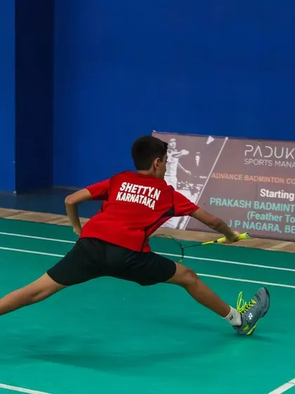 A junior player demonstrates a full-stretch lunge, showcasing the athleticism on display at our tournaments.