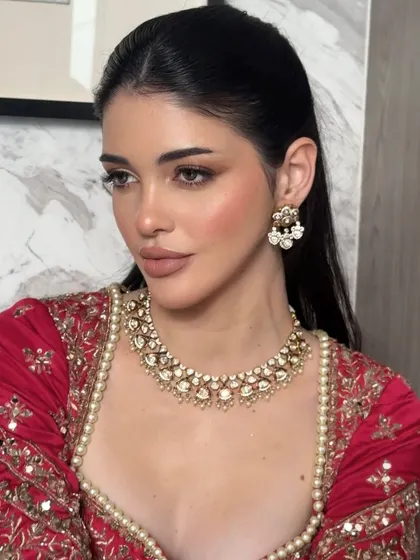 A close-up on the eyes and lips. The winged liner is sharp and precise, while the nude lip is perfectly defined, showcasing our technical skill in a soft glam context.