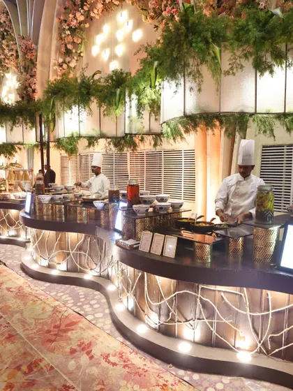A row of our chefs working in unison at a long, curved food station. This image showcases the scale of our operations and the professionalism of our team.