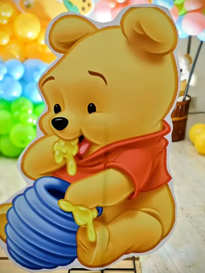 A cute Winnie the Pooh cutout with his honey pot, a sweet addition to Yashaswin's bee-themed party.