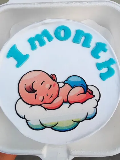 Celebrating one month with this adorable bento cake featuring a sleeping baby on a cloud.