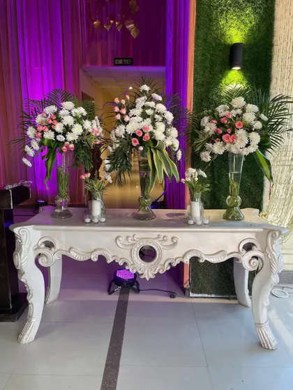 A modern console table with elegant floral arrangements. The clean lines of the table and the fresh flowers are perfect for a contemporary event.