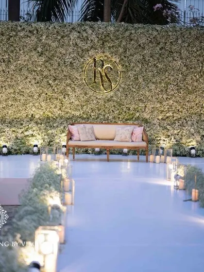 An ethereal all-white reception. The aisle and backdrop are adorned with clouds of baby's breath, while flickering candles cast a warm, romantic glow, creating a scene straight out of a fairy tale.