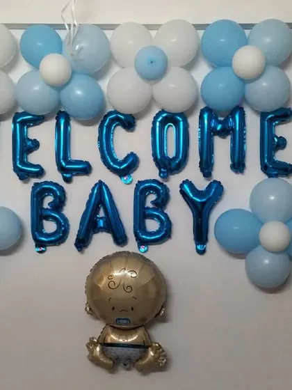 A simple wall decoration to welcome a baby. This includes 'Welcome Baby' foil letters, a baby-shaped foil balloon, and classic blue and white balloon clusters.