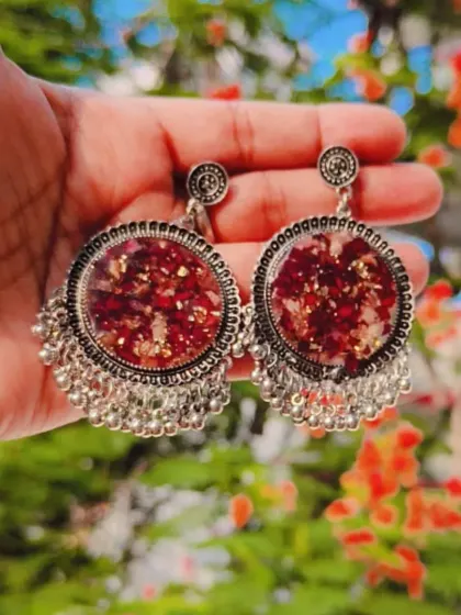 Matching jhumka earrings made with preserved flowers in resin. These traditional-style earrings are a beautiful way to wear your memories.