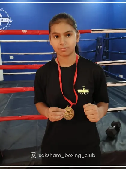 Hard work pays off. Here is one of my dedicated female boxers proudly displaying her medal, a testament to her commitment and the quality of our training.