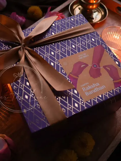 My Rakshabandhan hampers come in this royal purple and gold-foiled box. It's a luxurious way to gift my handmade candles and Rakhis to your siblings.