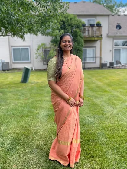 "Loved the saree!" A happy client from overseas, looking beautiful in her peach-colored saree.