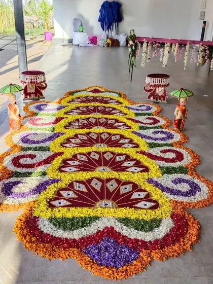 A vibrant floral rangoli with a fan-like pattern, created with multicolored petals. This intricate design adds a burst of color and artistry to the event floor.