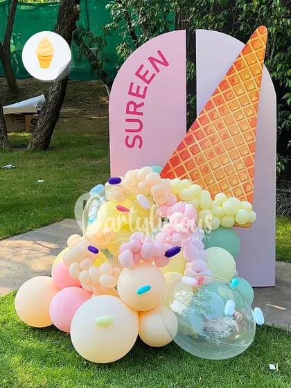 Here's the scoop. An ice cream theme is always a sweet choice. This personalized backdrop for Sureen features a giant cone with pastel balloon scoops, creating a perfect photo opportunity.