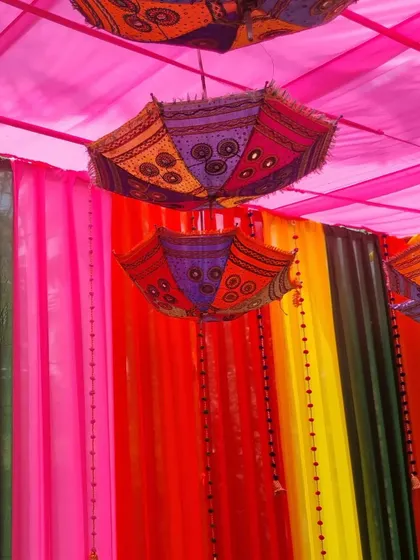A shot of the colorful drapes and hanging umbrellas, demonstrating the festive theme we created for a corporate celebration.