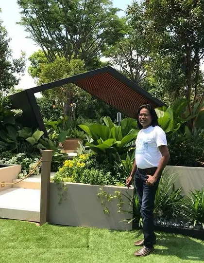 Different angles of a contemporary garden, showing the integration of raised planters with colorful flowers, a tranquil water body, and a modern gazebo. I am standing proudly by the finished project.