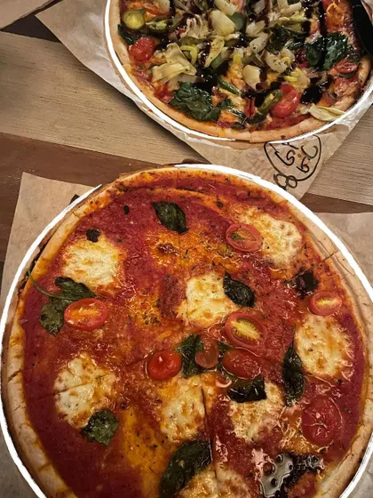A duo of delicious pizzas, each outlined with a simple white doodle to highlight their cheesy goodness.