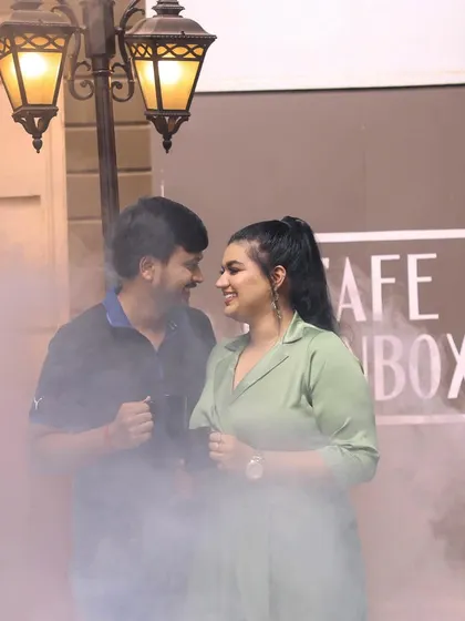 A romantic pre-wedding shot with a cafe theme, using atmospheric smoke and warm lighting to create an intimate mood.