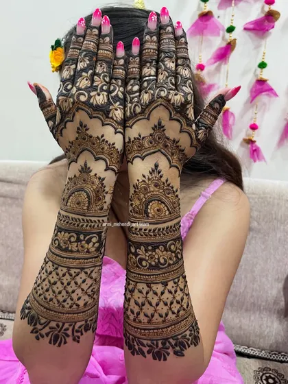 A beautiful pose showcasing a full coverage back-hand bridal design. The pattern features classic jaali work, floral bands, and scalloped edges for a rich and complete look.