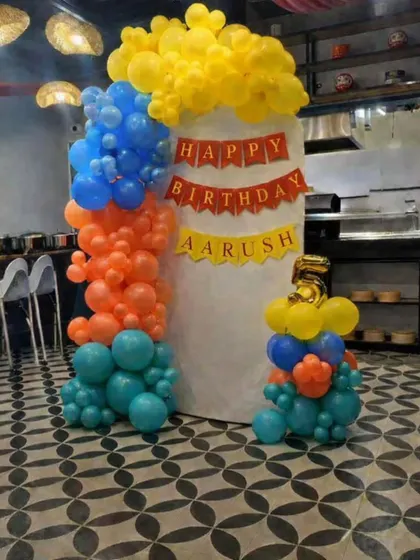 Even a structural element like a pillar can become a festive decoration. For this restaurant birthday party, I wrapped a large pillar with a vibrant organic balloon garland in yellow, blue, orange, and teal.