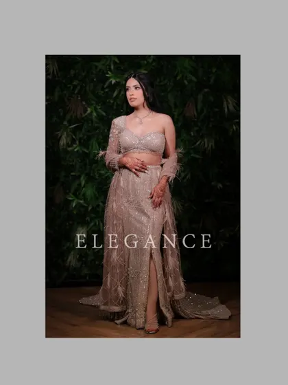 A full-length portrait showcasing Proumya's elegant and modern engagement gown with a thigh-high slit and feathered sleeves.