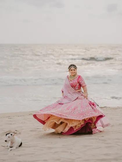 A bride twirling on the beach in Goa, with a furry friend enjoying the view. We love capturing these spontaneous, happy moments that make your day special.