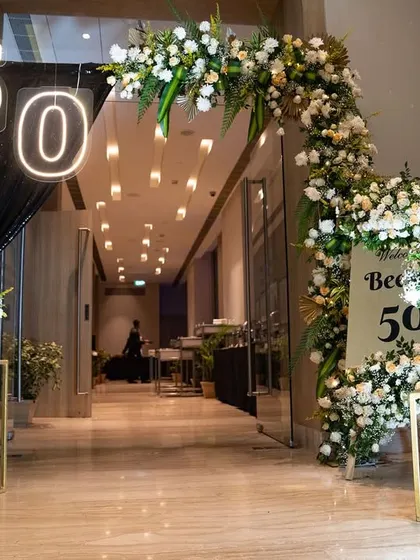The grand entrance for the 50th birthday celebration was designed to make a statement. The floral archway and neon numbers created an exciting and glamorous entryway for the surprise party.