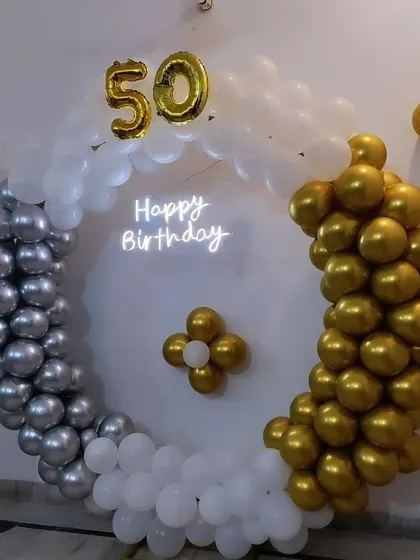 A closer look at the 50th birthday balloon ring, showing the color blocking of silver and gold balloons.