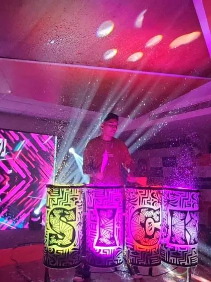 A wide shot of the liquid drum setup on stage, with the drums spelling out "SICK" and creating a cool visual centerpiece.