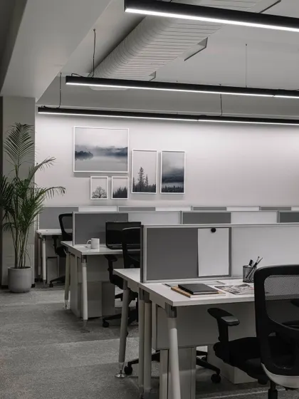 For this pharma office, we designed for productivity with sleek, linear workstations. The space is optimized with pinnable boards, movable storage, and a calming palette of whites and greys, while artwork adds a touch of personality.