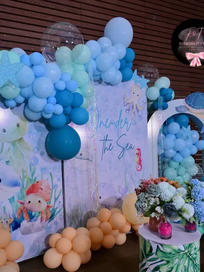 A detailed shot of the 'One-der the Sea' backdrop, with its beautiful underwater graphics and surrounding balloon garland.