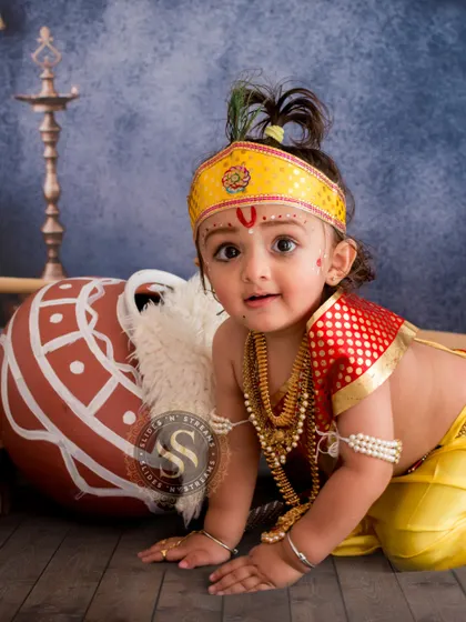 Capturing a moment of playful curiosity during a Krishna themed shoot. This crawling pose adds a dynamic and adorable element to the traditional baby photoshoot.
