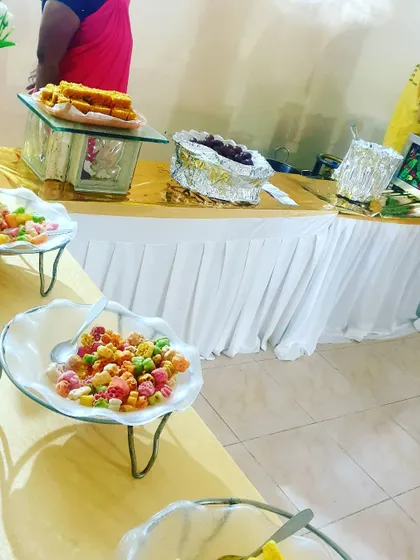 A close-up of the snack and dessert section of a buffet, featuring colorful candies and traditional Indian sweets.