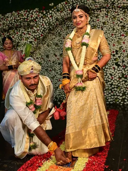 A sacred moment from a South Indian wedding, with the groom performing a ritual on the bride's mehendi-adorned feet.