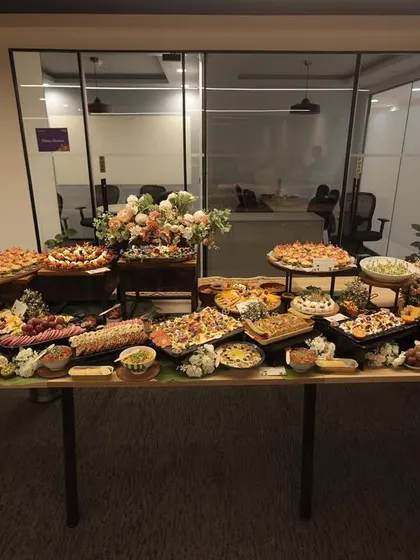 A wide shot of a long grazing table set up in a modern office space. This demonstrates how I can transform any venue into a gourmet experience, perfect for corporate gatherings and celebrations.