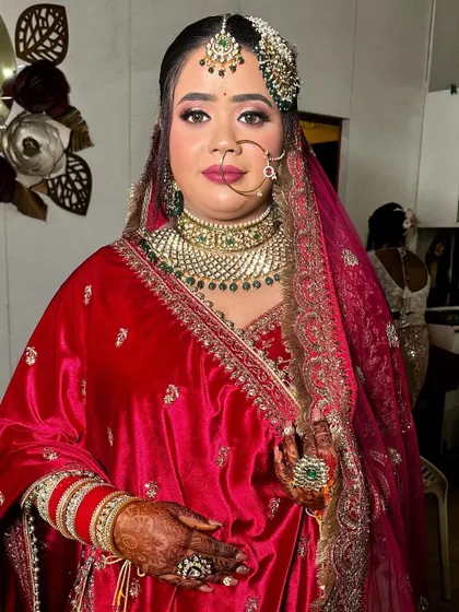 A portrait of my bride in her red velvet outfit. The makeup features a sharp wing liner and a deep pink lip for a classic bridal look.