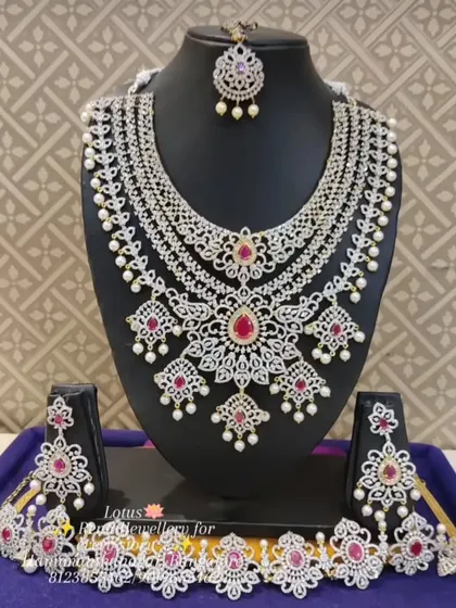 A full American diamond bridal set with ruby stones and pearl drops, including a matching choker and vaddanam.