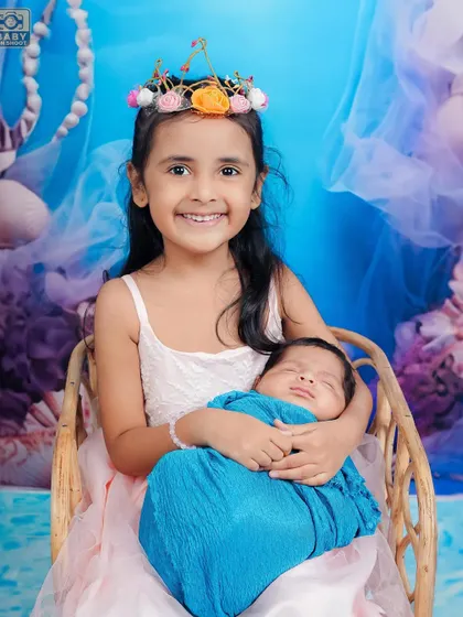 Capturing the bond between siblings is one of my favorite things to do. Here, a proud big sister holds her newborn brother, creating a truly special memory. I ensure these newborn and sibling photoshoots are always safe and gentle.