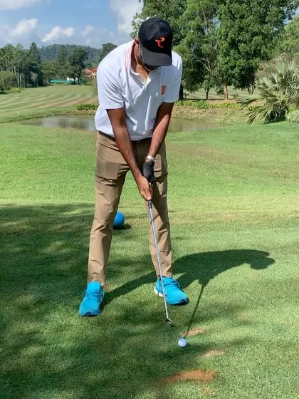 Tennis champion Rohan Bopanna preparing to hit a shot on the fairway. It's fascinating to see how the coordination and power from one sport can translate to another.