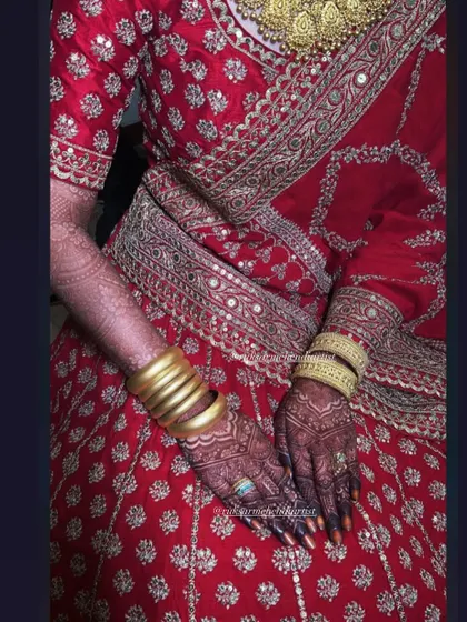 A full view of the bridal lehenga with the beautifully stained hands, a complete and regal look.