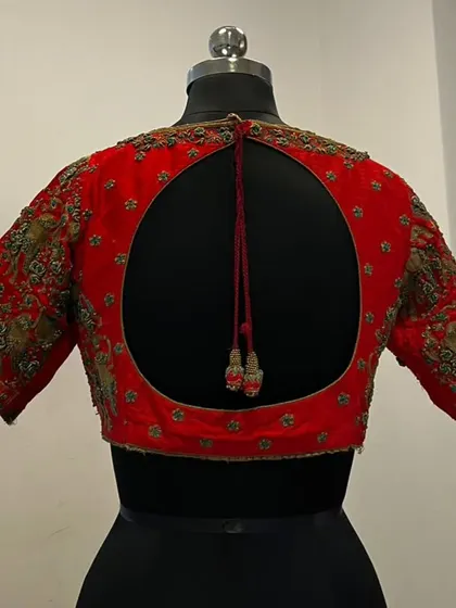 The back of the red bridal blouse, featuring a modern and elegant circular keyhole opening.