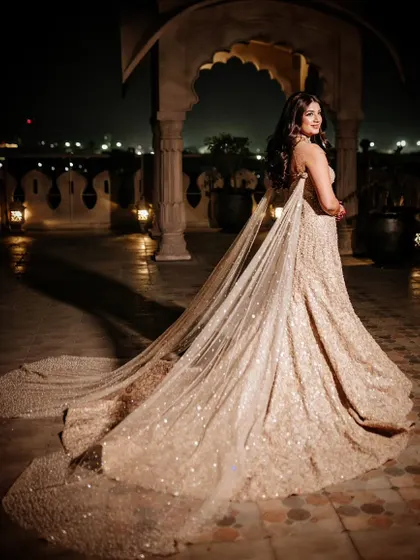 The bride's breathtaking look for her cocktail night, featuring a stunning gown with a dramatic trail. I ensure my brides feel like stars on their special day.