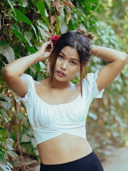 A softer, more natural portrait amidst lush greenery. The red rose in her hair adds a touch of romance to this beautiful solo shot.