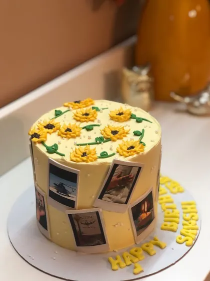 A cheerful sunflower-themed cake with a polaroid photo collage, making it a truly personal gift.