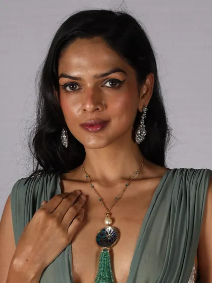 A model ready for the runway with a classic winged eyeliner and elegant jewelry. This timeless look is a staple in any professional makeup artist's skill set.