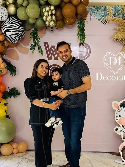 The happy family posing at their son's jungle-themed first birthday party.