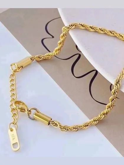 A detailed shot of the gold-toned rope bracelet, showing the adjustable clasp and high-quality 18K stamp.