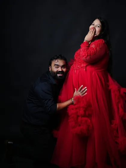 A fun and candid moment during a couple's session. The partner's playful reaction while listening to the baby bump brings a sense of joy and personality to the shoot.
