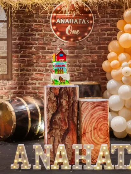 A full view of the barnyard party stage, with a custom 'Anahata's One' sign and rustic props.