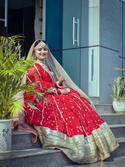 This image captures the complete bridal ensemble created by a student. The pose and setting are chosen to highlight the rich colors of the outfit and the elegance of the overall look.